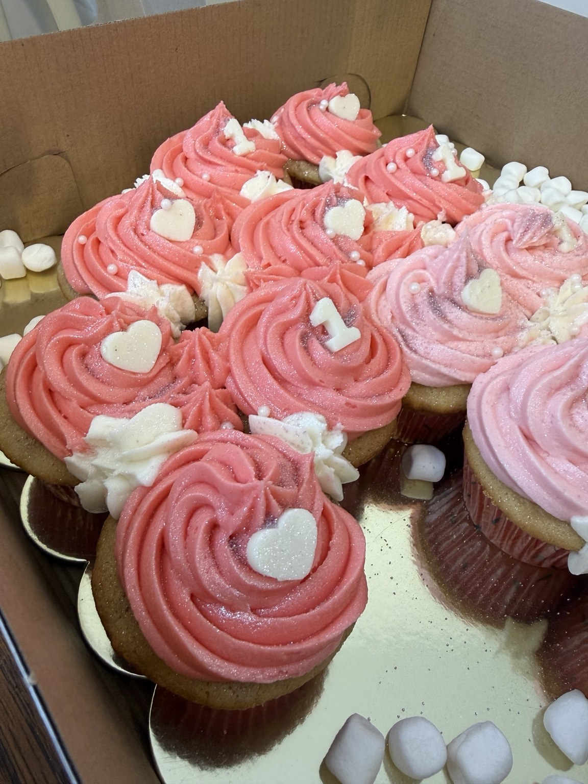 Close-up of pink first birthday cupcakes by CakedByKim